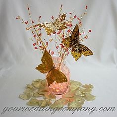 a vase filled with flowers and butterflies on top of a table