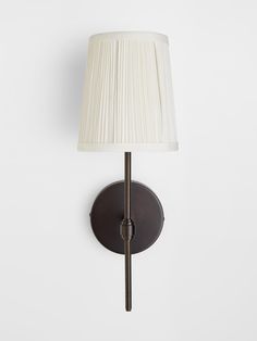 a wall light with a white shade on it