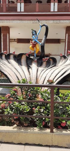 a statue of a man riding on the back of a bird in front of a building