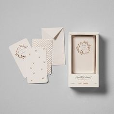 three cards in a white box with gold foil on the front and one card inside