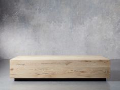 a large wooden box sitting on top of a floor next to a concrete wall in an empty room