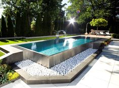 an outdoor swimming pool surrounded by rocks and gravel