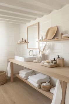 a bathroom with two sinks and towels on the counter top, along with other items