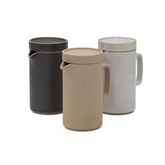 three different colored coffee mugs sitting next to each other