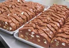 two trays filled with different types of chocolate desserts on top of a table