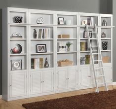 a ladder leaning against a white bookcase filled with books