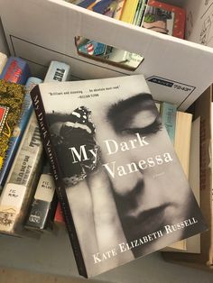 a book sitting on top of a white shelf next to bookshelves filled with books