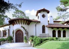 a large white house with an arched door and steps leading up to the front entrance