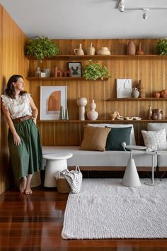 a living room filled with lots of furniture and decor on top of wooden shelving