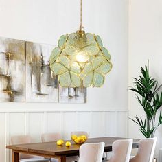 a dining room table with chairs and a chandelier hanging from the ceiling