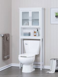 a white toilet sitting in a bathroom next to a cabinet