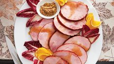 slices of ham on a plate with mustard and seasoning