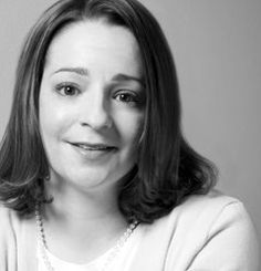 a black and white photo of a woman smiling at the camera with her eyes wide open