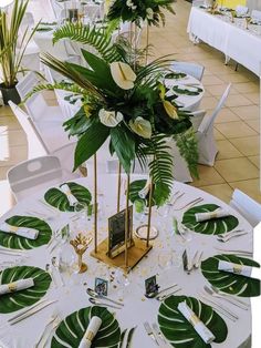 there is a table set up with white and green decorations