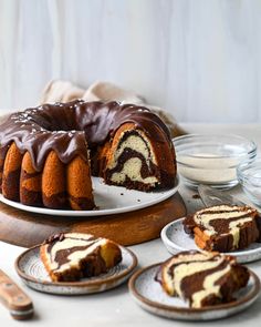 a bundt cake with chocolate icing on a plate next to other desserts