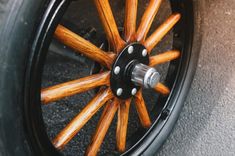 the spokes and hubs of a car wheel are made out of black wood