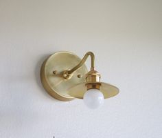 a light that is on the wall next to a white wall with a small bulb