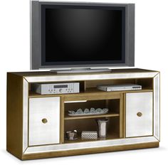 an entertainment center with a flat screen tv on it's side and gold trimmings