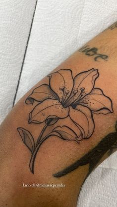 a close up of a person's arm with a flower tattoo on it