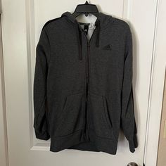 Gray Adidas Zip Up Hoodie In Size Medium. Never Worn. Cozy Sports Outerwear With Double-lined Hood, Adidas Fall Outerwear With Drawstring Hood, Adidas Outerwear With Drawstring Hood For Fall, Gray Fleece Sweatshirt For Cold Weather, Gray Fleece Outerwear With Ribbed Cuffs, Adidas Sweatshirt With Double-lined Hood For Fall, Adidas Winter Hooded Jacket With Drawstring Hood, Adidas Hooded Outerwear With Ribbed Cuffs, Adidas Winter Track Jacket With Ribbed Cuffs