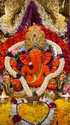 the statue of ganesh is surrounded by flowers and other decorations in front of it