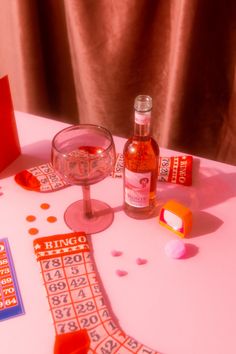 a table topped with a bottle of liquor next to a game board and dices