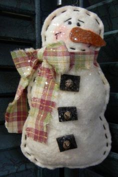 a snowman made out of buttons and fabric