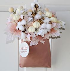 a vase filled with lots of white and pink flowers next to a door handle that says hello pumpkin