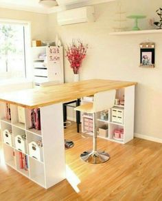 a room with a desk, shelves and some drawers on the wall next to it