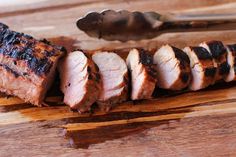 slices of meat sitting on top of a wooden cutting board