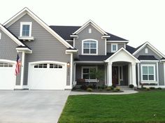 a gray house with white trim on the front and side windows is shown in an iphone photo