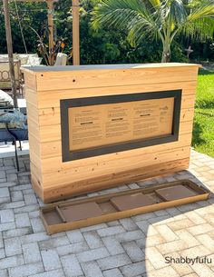 a large wooden box sitting on top of a brick patio