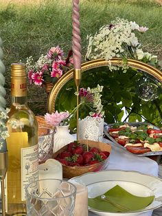 the table is set with food and wine for an outdoor dinner or brunch