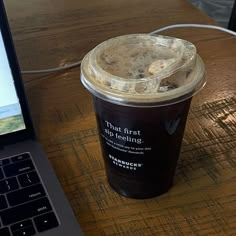 a cup of coffee sitting next to a laptop computer