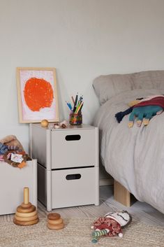 a small child's bedroom with two drawers and toys on the floor next to it