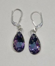 These beautiful sterling silver earrings have sparkling 16x9mm Swarovski Crystal Vitrail Light pear-shaped drops hung on a closure of your choice.Crystal Vitrail Light is a beautiful blend of pinks, purples, and blues that vary in intensity depending on the angle of light.Choose Closure: Fishhook Earwire or LeverbackEarwires come with rubber earnut backs in order to secure them on your ears; leverback have a secure attachment.**Matching Necklace Available Nickel Free Purple Teardrop Crystal Earrings, Nickel-free Purple Teardrop Crystal Earrings, Purple Sterling Silver Teardrop Earrings, Purple Teardrop Crystal Earrings With Ear Wire, Purple Teardrop Crystal Earrings, Purple Teardrop Crystal Earrings In Sterling Silver, Crystal Teardrop Earrings, Secure Attachment, Mirror Ornaments