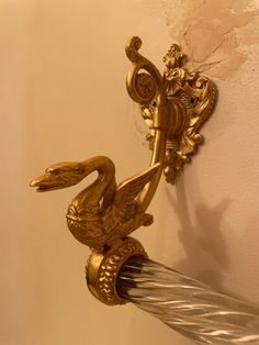 a gold swan hook is attached to the wall