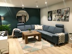 a living room with blue couches and pictures on the wall above it, along with a coffee table