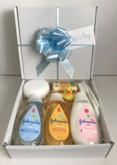 an open gift box containing baby products and a blue bow on the top of it