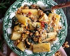 two plates filled with pasta and meat on top of a wooden table