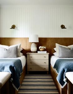 two beds in a bedroom with blue and white bedding