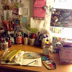 the desk is full of art supplies and office supplies