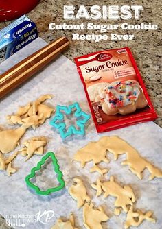 some cookies are sitting on a table with icing and other items to make them look like they're ready for christmas