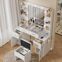 a white vanity table with drawers and lights on the top, in front of a window