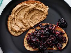 two pieces of toast with peanut butter and berries on it