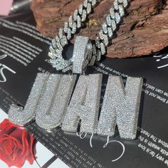 a couple of necklaces sitting on top of a table next to a rock and a rose