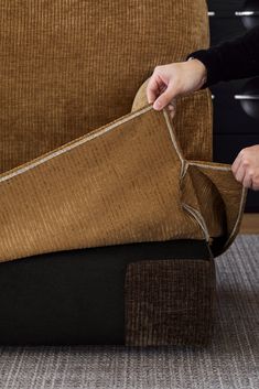 a person is opening up a couch cushion