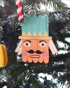 a christmas ornament hanging from a tree decorated with paper cut outs and decorations