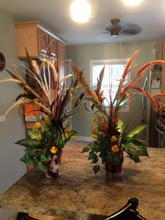 two vases filled with flowers on top of a counter