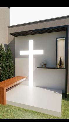 a white cross sitting on top of a wooden bench in front of a wall and window